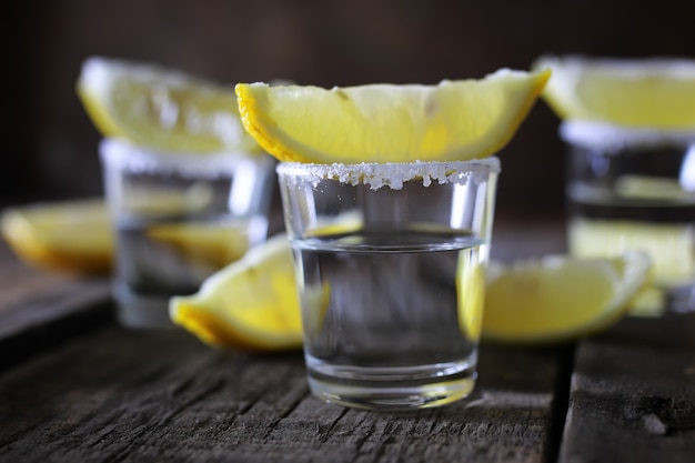 Pila de tequila con sal y limón sobre un fondo de madera