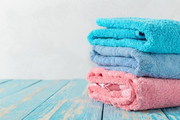 Pila de toallas de baño en mesa de madera con espacio de copia