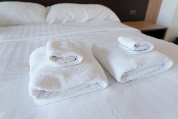 Pila de toallas en la cama en un dormitorio moderno en el hotel
