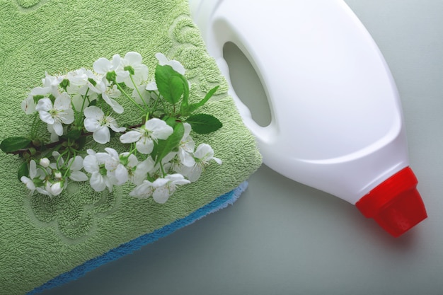 Pila de toallas con flores y una botella de detergente.