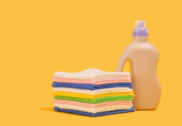Una pila de toallas limpias de colores y detergente para la ropa Copiar espacio para el texto