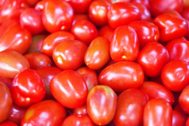 Pila de tomates ciruela roja un puesto en el mercado