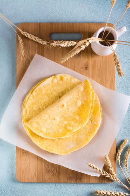 Pila de tortillas de maíz mexicanas planas sobre tablero de madera en la mesa Vista superior y vertical