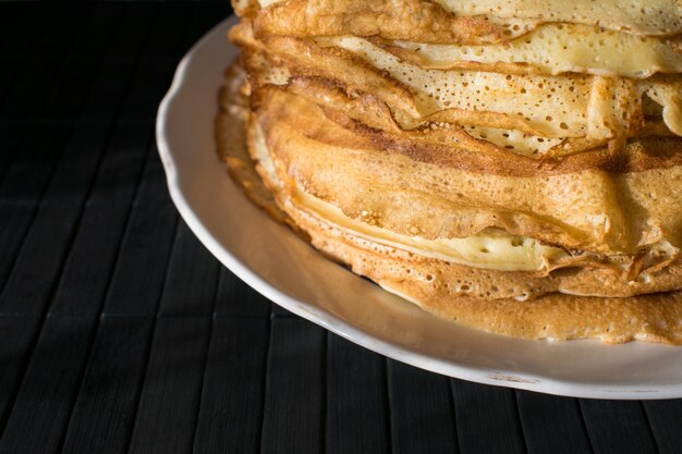 Pila de tortitas inglesas en un plato redondo blanco