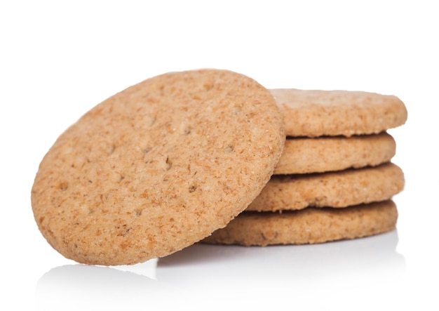 Pila de trigo crujiente orgánico redondo y galletas saladas de cinco granos sobre fondo blanco