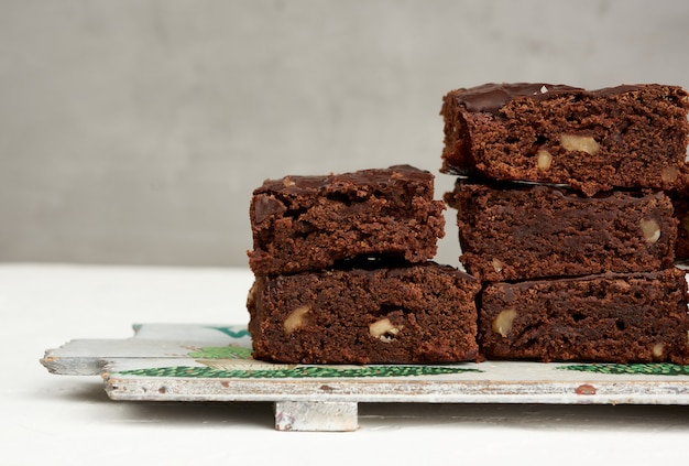 Pila de trozos cuadrados de pastel de chocolate con nueces horneadas