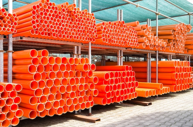 Pila de tuberías de agua de pvc naranja en zona industrial abandonada