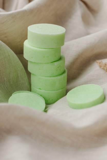 Pila de una variedad de pastillas de jabón natural con lavanda sobre tela de lino colores pastel