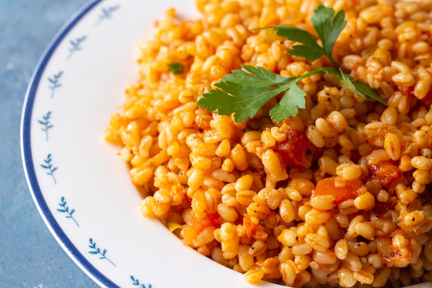 Pilaf bulgur turco tradicional con salsa de tomate en el plato nombre turco meyhane pilavi