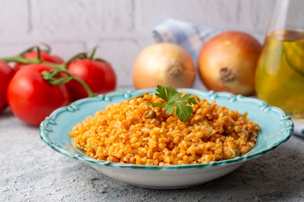 Pilaf de bulgur turco tradicional con salsa de tomate en plato (nombre turco; meyhane pilavi)