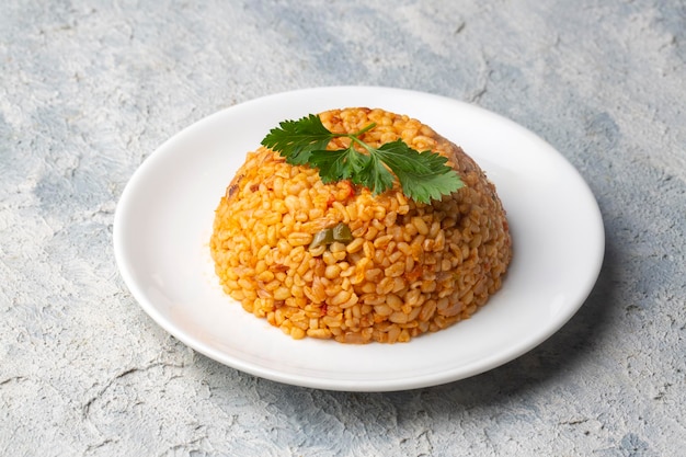 Pilaf de bulgur turco tradicional con salsa de tomate en plato (nombre turco; meyhane pilavi)