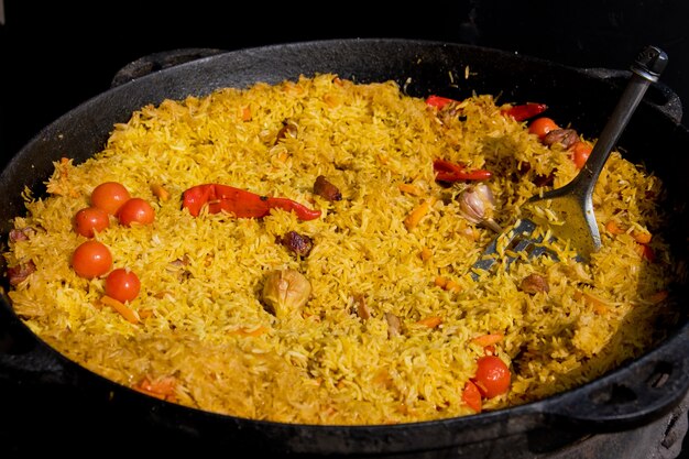 Pilaf cocido en un caldero grande. Festival de comida callejera. Enfoque selectivo.