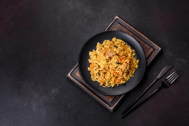 Pilaf com frango Prato quente oriental tradicional de legumes de carne de frango de arroz cozido e especiarias num prato