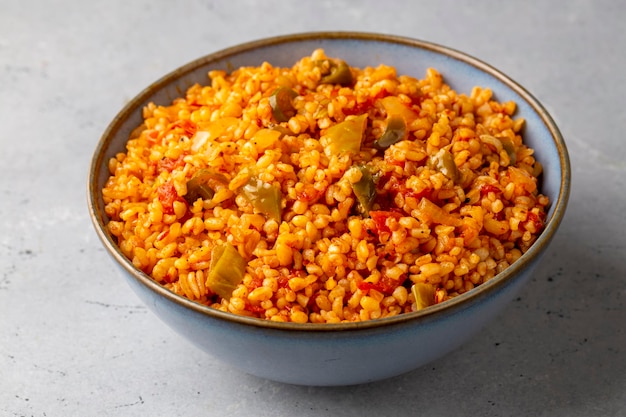 Pilaf turco tradicional de bulgur com molho de tomate no prato (nome turco; meyhane pilavi)