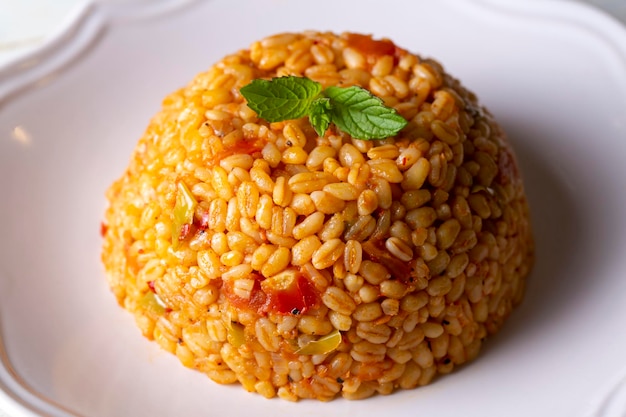 Pilaf turco tradicional de bulgur com molho de tomate no prato (nome turco; meyhane pilavi)