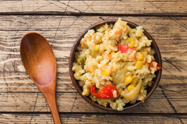 Pilaf con verduras y pollo en un tazón de madera