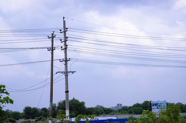 Pilão de eletricidade de alta tensão sob o céu azul nublado