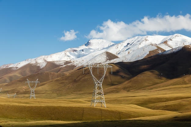 Pilão de eletricidade, linhas de energia nas montanhas, Quirguistão, Kyzart Pass, Kochkor District, Naryn Region