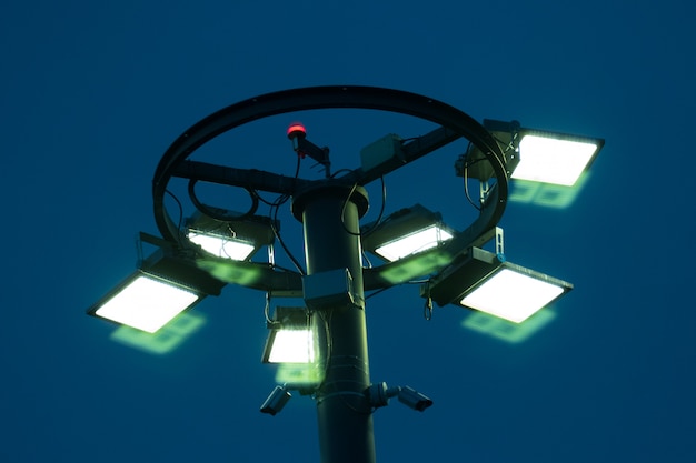 Foto pilar com holofotes em chamas na noite azul.