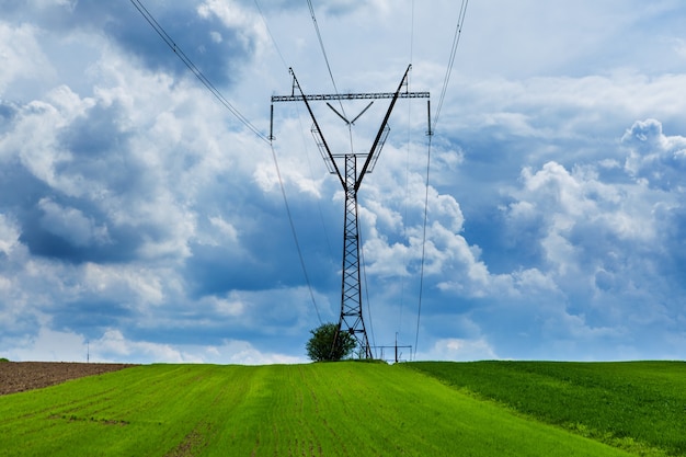 Pilar de transmissão de eletricidade em silhueta contra o céu azul