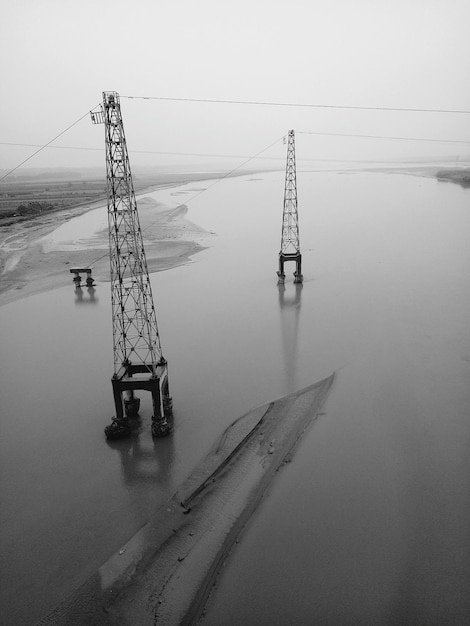 Foto pilares de electricidad en el río