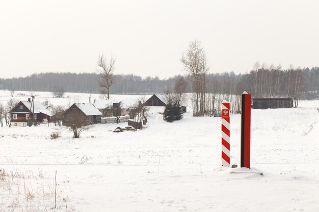 Pilares fronterizos de Bielorrusia y Polonia en la frontera en un campo de invierno