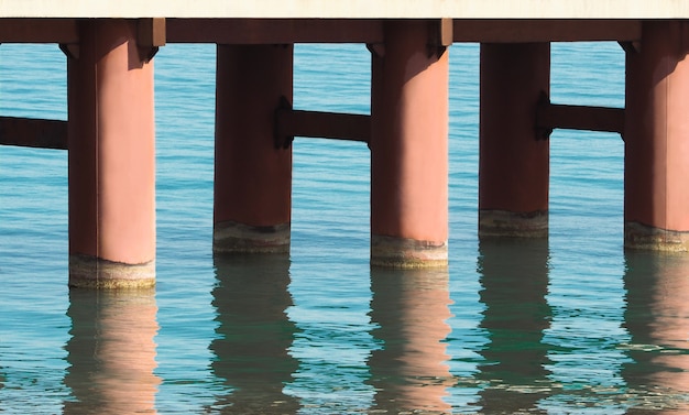 Pilares del puente con reflejo de agua. Fondo de construcción
