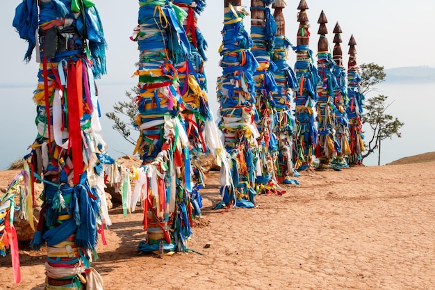 Pilares sagrados com fitas amarradas nas tradições de cape burhan da ilha de olkhon buryat