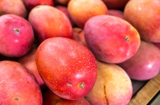 Pilas de frutos de mango en color rojo vivo en el mercado tradicional, Taiwán