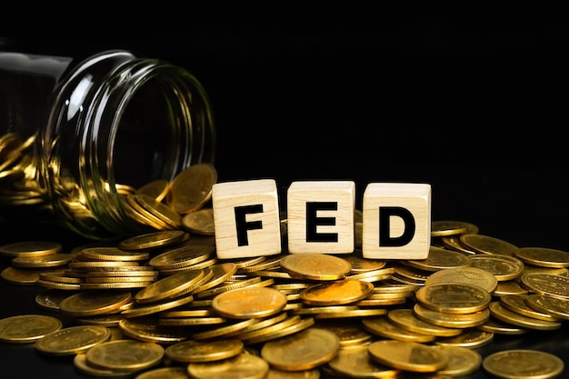 Pilas de monedas de oro con las letras FED en un cubo de madera Concepto de negocio