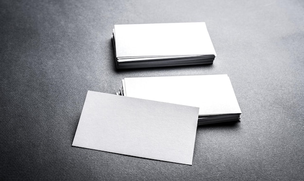 Pilas de tarjeta de visita blanca en blanco sobre fondo gris tarjeta de nombre en blanco