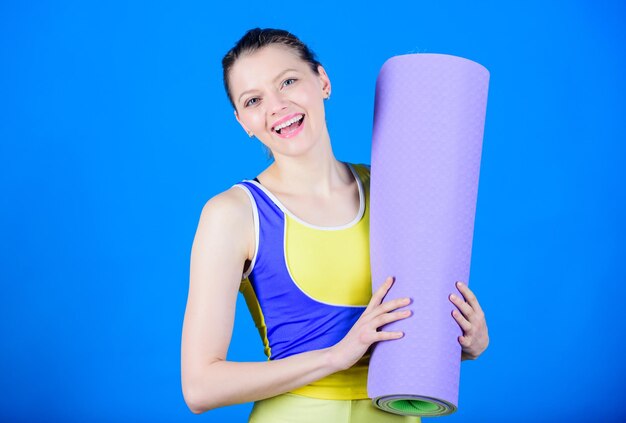 Pilates-Erfolg Sportmattenausrüstung Sportliche Fitness Sportliche Frau beim Training im Fitnessstudio Starke Muskeln und Kraft Glückliches Frauentraining mit Fitnessmatte, das Pilates-Pilates-Studiotraining praktiziert