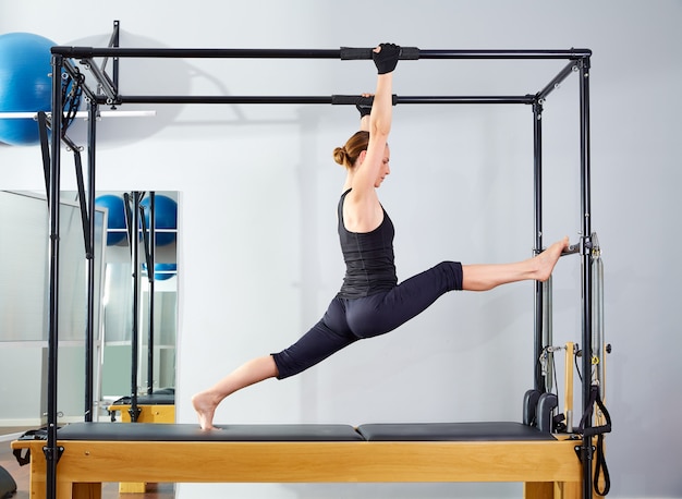 Pilates-Frau in Cadillac-Beinen spaltete Reformer auf