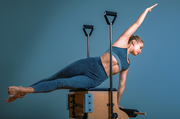 Foto pilates-frau in einem reformer macht dehnungsübungen im fitnessstudio fitnesskonzept spezielle fitness