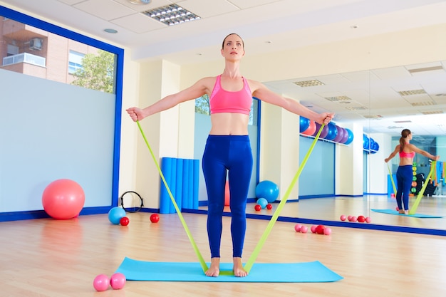 Pilates mujer de pie ejercicio de goma