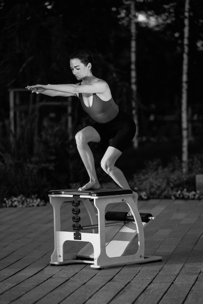 Pilates reformador silla mujer fitness yoga gimnasio ejercicio. Corrección del sistema musculoesquelético.