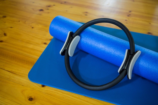 Pilates Ring und Trainingsmatte auf Holzboden gehalten