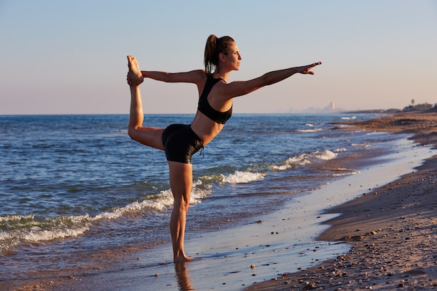 Pilates-Yoga-Trainingsübung im Freien am Strand