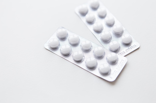 Píldoras blancas en un blister aislado sobre un fondo blanco Lugar para una inscripción El concepto de salud y medicina