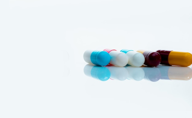 Píldoras de cápsulas antibióticas sobre fondo blanco Medicamentos recetados Píldoras de cápsulas coloridas Antibiótico
