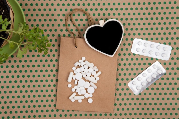 Píldoras y cápsulas blancas bolsa de regalo hecha a mano y pizarra en blanco en forma de corazón