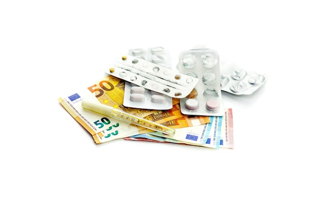 Píldoras y euros en un primer plano de fondo blanco