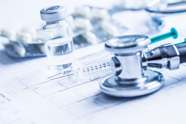 Píldoras de inyecciones de estetoscopio en el gráfico de EKG - elektrokardiogram.