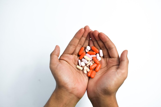 Foto píldoras de medicina coloridas en el hombre dos manos sobre fondo blanco