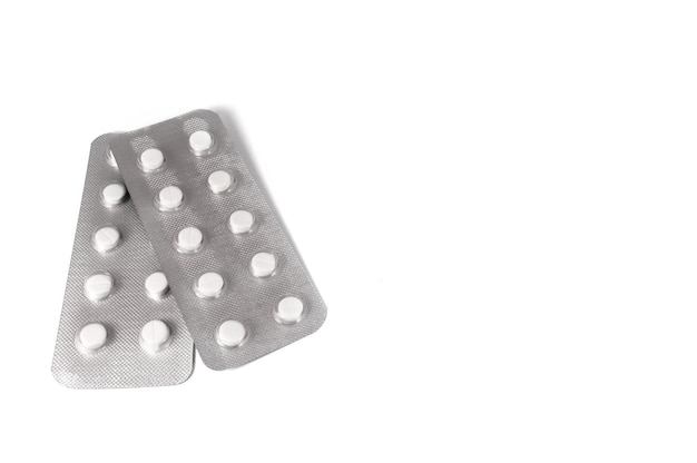 Píldoras y tabletas médicas blancas sobre fondo blanco Foto de primer plano de preparaciones médicas con espacio de copia