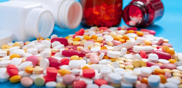 Píldoras y tabletas médicas que se derraman de una botella de droga