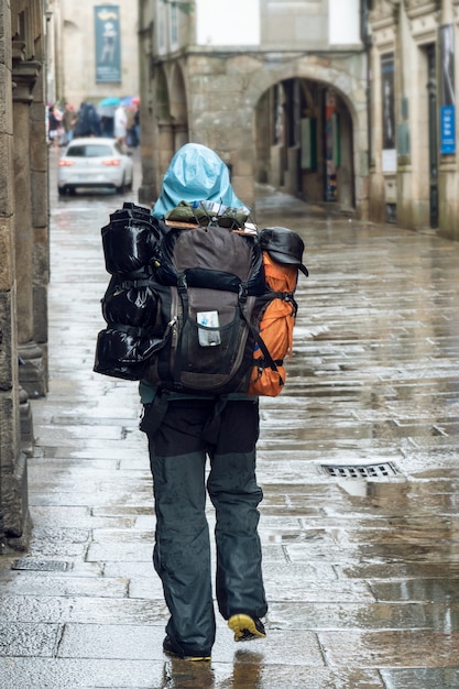 Pilger, der auf regnerischer tagesstraße der alten stadt von santiago de compostela geht