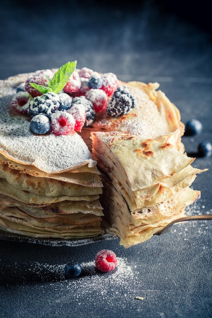 Pilha caseira de panquecas com frutas e açúcar em pó