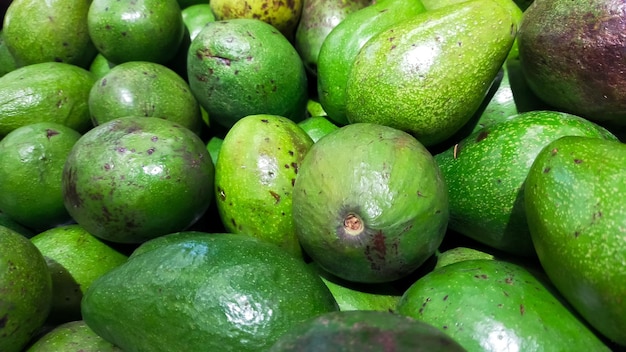 Pilha de abacates verdes no mercado para venda