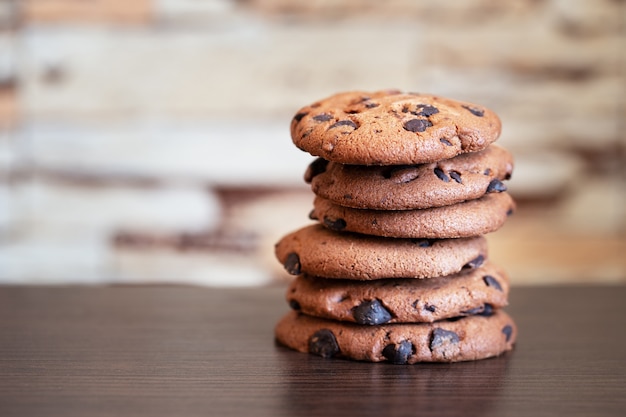 Pilha de biscoitos de aveia com chocolate em uma mesa de madeira